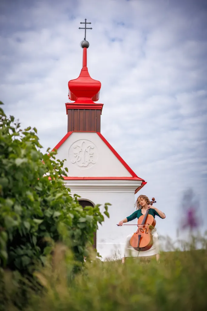Radka Těšíková s violoncellem u kapličky